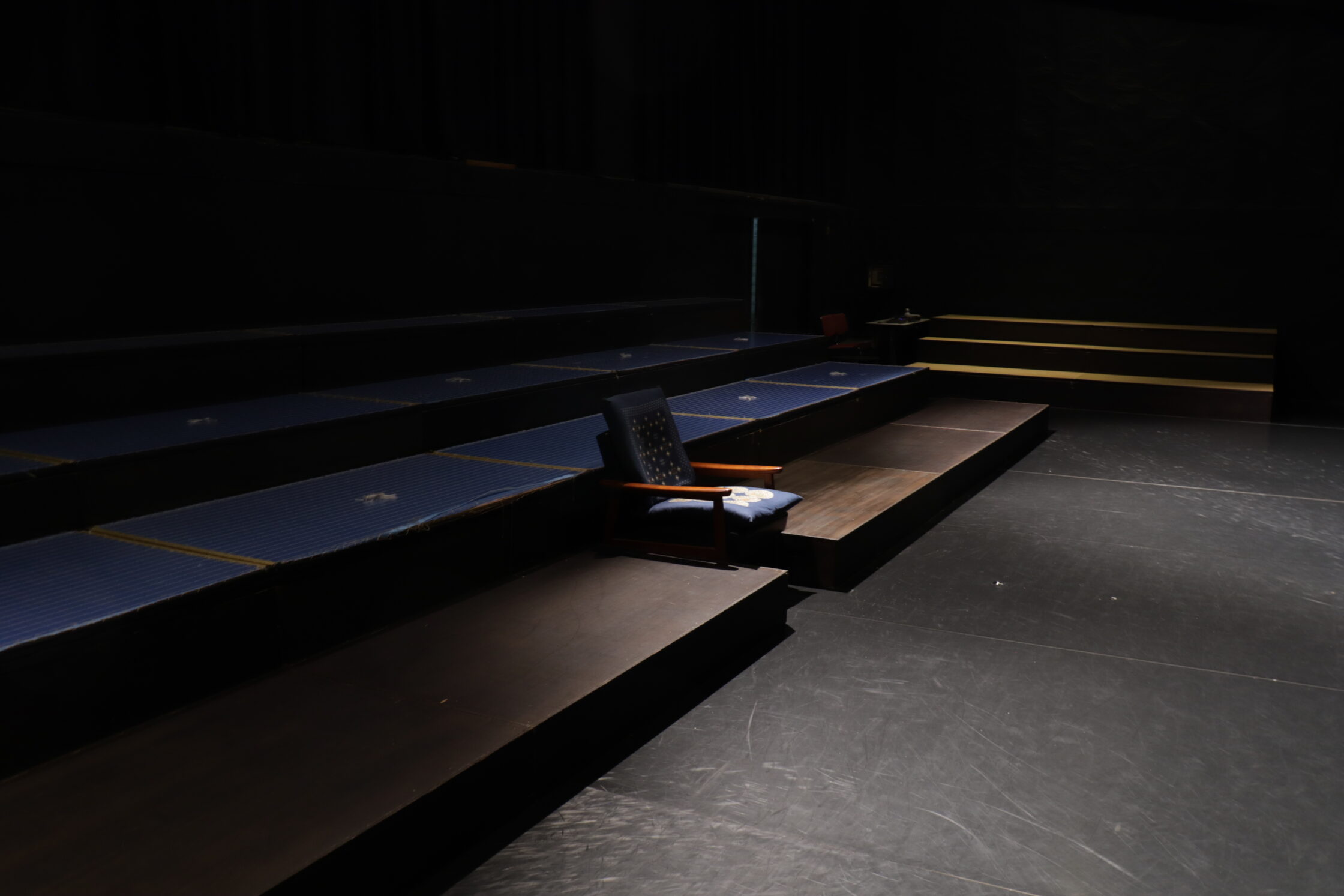 Una poltrona la centro di due tribune in una stanza da training per attori